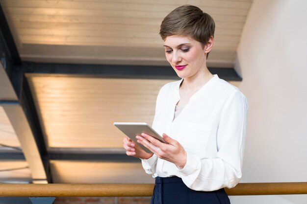 Femme souriante regardant la tablette