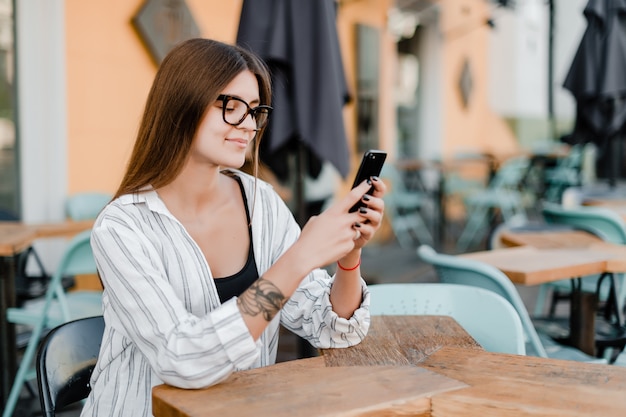 Femme souriante regarde son téléphone