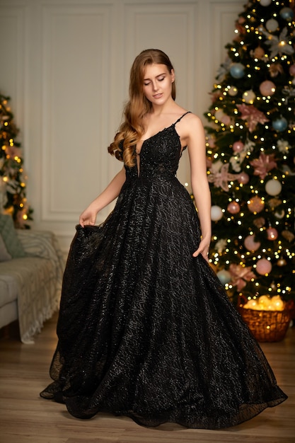 Femme Souriante En Robe De Soirée Sur L'arbre De Noël