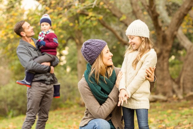 Femme souriante avec sa fille contre son mari et son fils