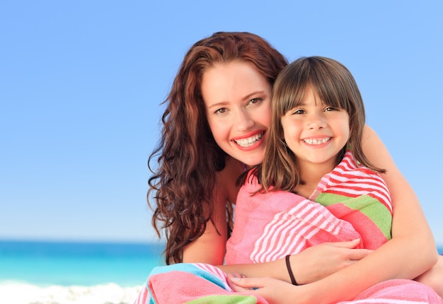 Femme souriante avec sa fille dans une serviette