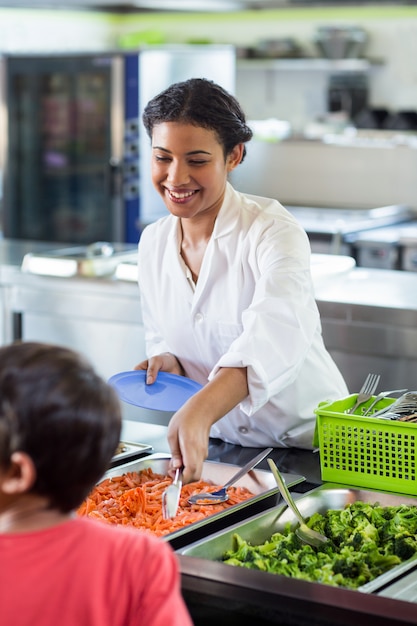 Femme souriante, servir, nourriture, à, écolier