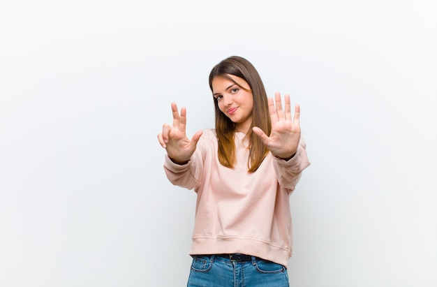 Femme souriante et sympathique, montrant le numéro huit ou huitième avec la main vers l'avant, compte à rebours