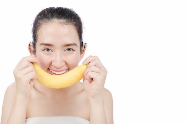 Femme souriante tenant une banane