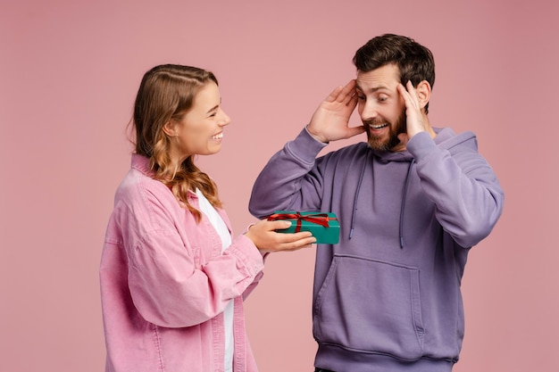 Une femme souriante tenant une boîte à cadeaux pour son beau petit ami sur un fond punk