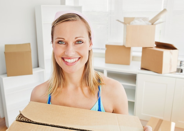 Femme souriante tenant des boîtes après le déménagement