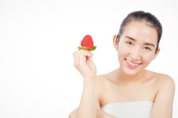 Femme souriante tenant une fraise