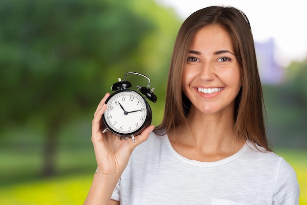 Femme souriante tenant une montre d&#39;alarme