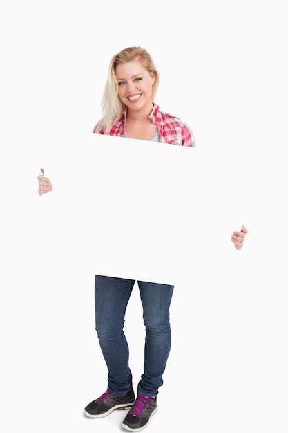 Femme souriante tenant une pancarte blanche