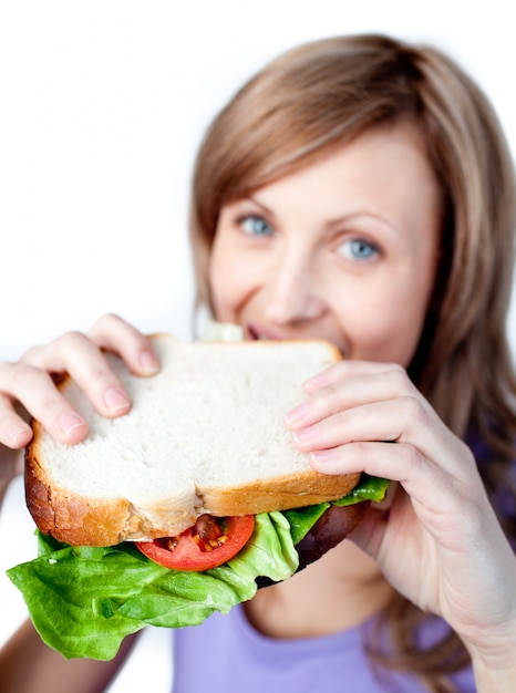 Femme souriante tenant un sandwich