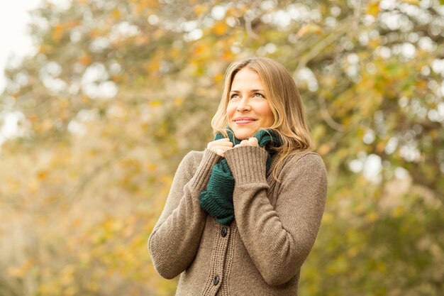 Femme souriante tenant son écharpe