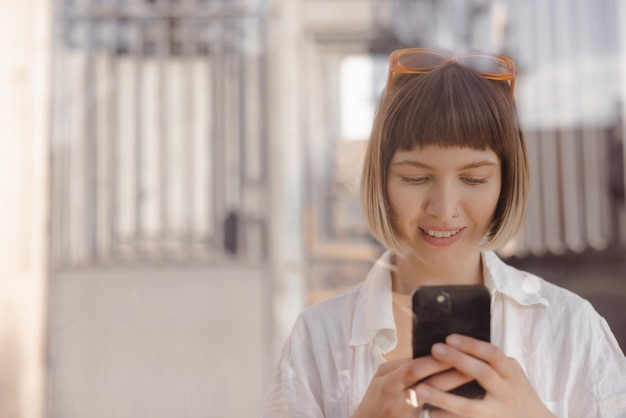 Femme souriante tenant son téléphone