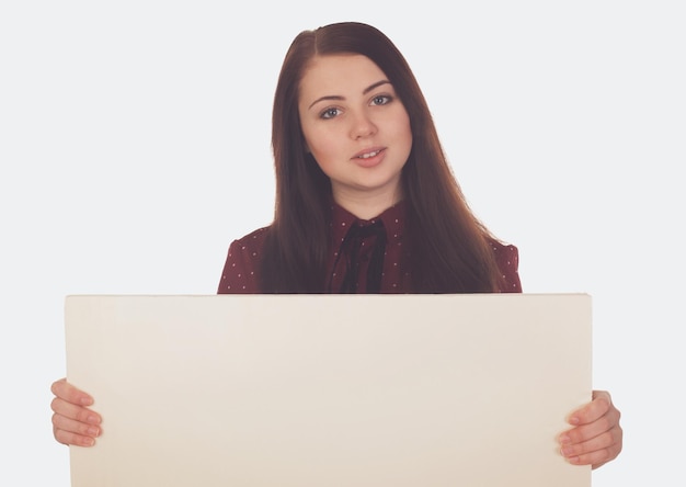 La femme souriante tient une toile blanche