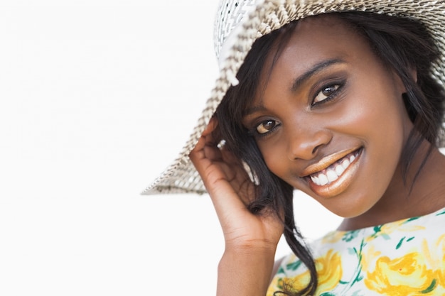 Femme souriante tout en portant un chapeau d&#39;été