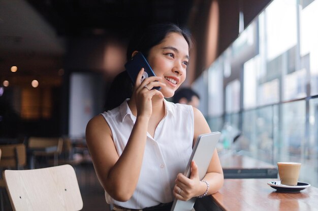 Une femme souriante utilisant un téléphone portable.