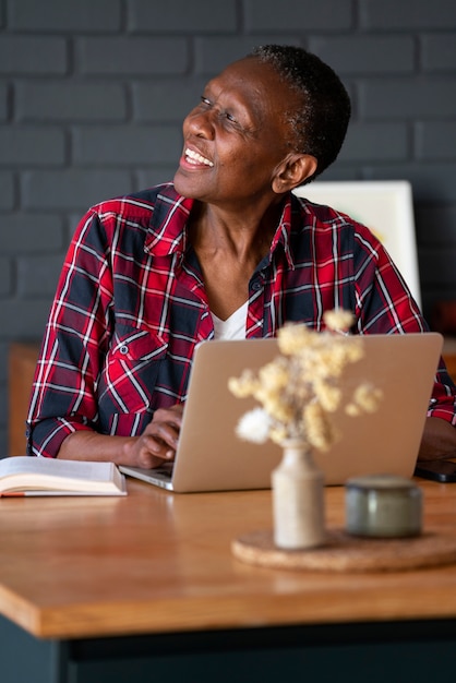 Photo femme souriante vue de face travaillant sur ordinateur portable