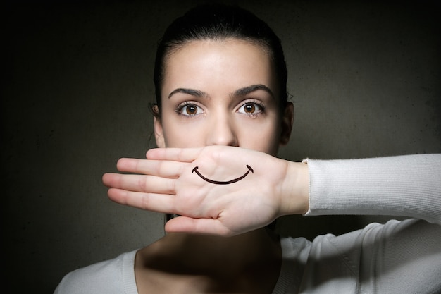 Photo femme avec le sourire peint sur la main