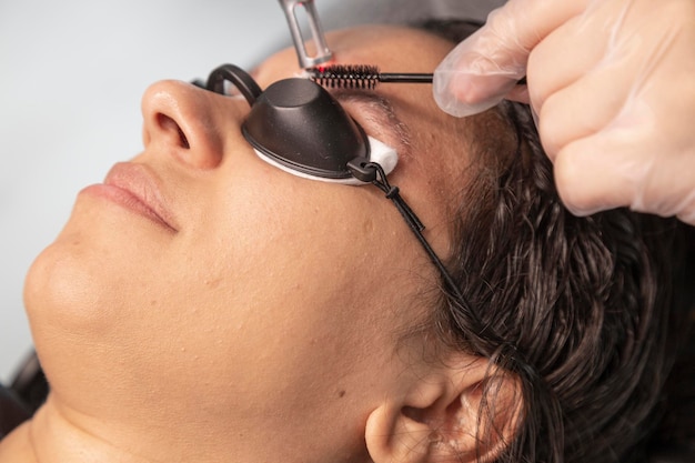 Photo femme avec un sourire sur son visage enlevant le tatouage de sourcil avec le laser