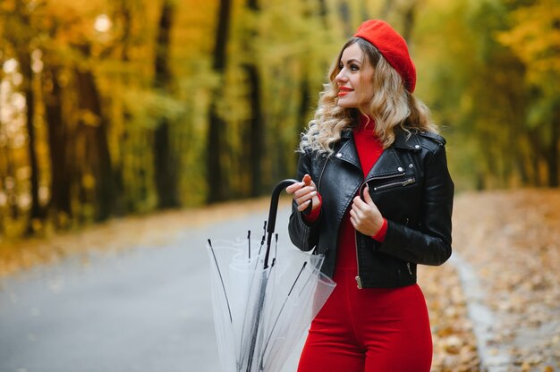 Femme sous parapluie se promène dans le parc en automne