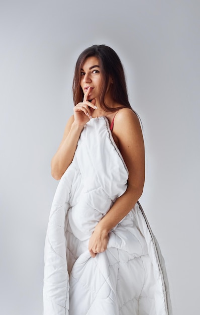 Femme en sous-vêtements en studio sur fond blanc.