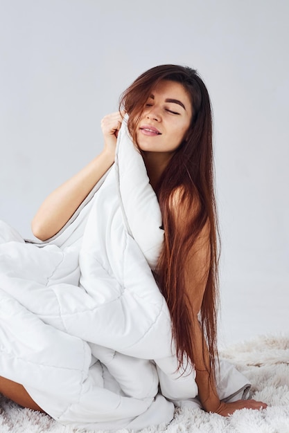 Femme en sous-vêtements en studio sur fond blanc.