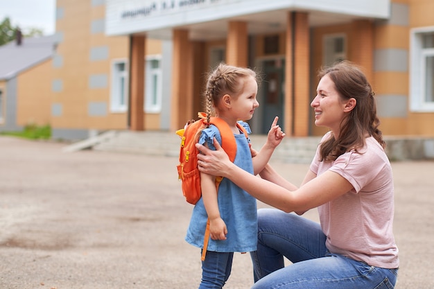 La femme soutient moralement la fille qui se tient par la main encourage l'enfant.