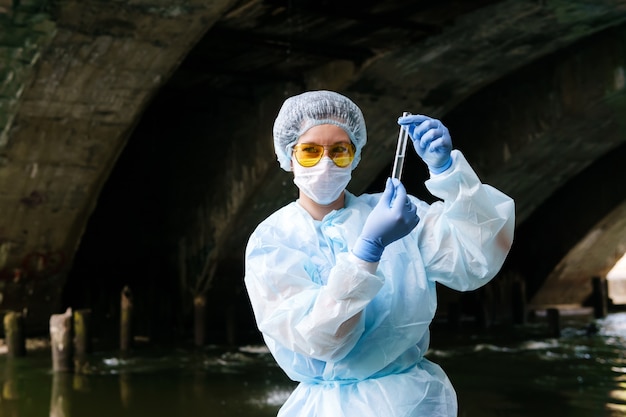 Photo une femme spécialiste de l'environnement ou du contrôle sanitaire démontre un tube à essai avec de l'eau