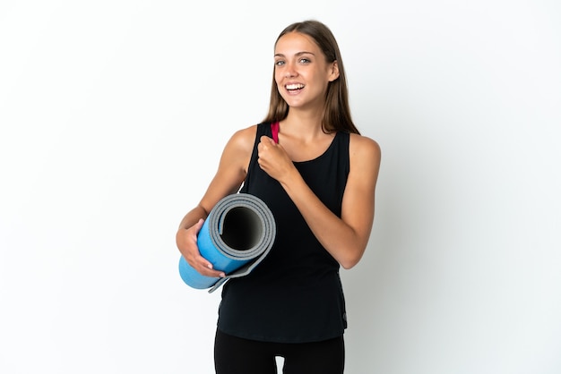 Femme de sport allant à des cours de yoga tout en tenant un tapis sur fond blanc isolé célébrant une victoire