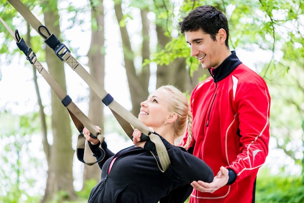 Femme de sport avec entraîneur à la formation de fronde