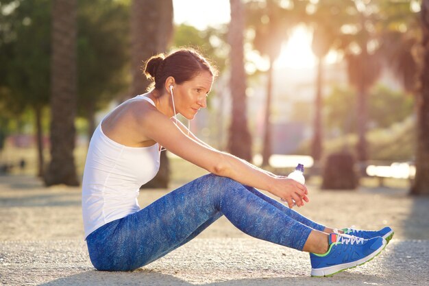 Femme de sport fatigué assis à l&#39;extérieur