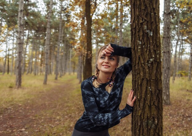 Femme de sport fatigué en vêtements de sport dans la forêt d'automne