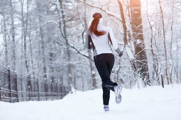 Femme sport jogging le matin du parc d'hiver