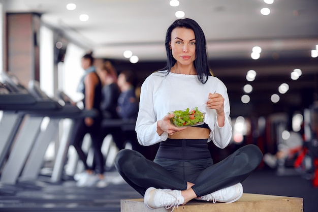 Femme de sport mangeant de la salade