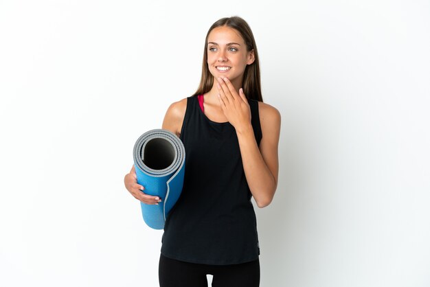 Femme sportive allant à des cours de yoga tout en tenant un tapis isolé