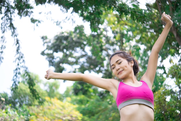 Femme sportive asiatique étirant les bras respirant de l'air frais dans le concept d'exercice de personnes parkThailand