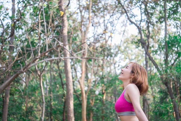 Femme sportive asiatique étirant les bras respirant de l'air frais dans le concept d'exercice de personnes parkThailand