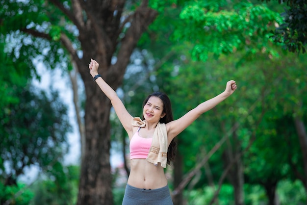 Femme sportive asiatique étirant les bras respirant de l'air frais dans le concept d'exercice de personnes parkThailand