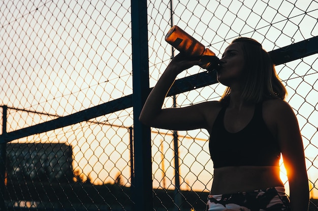 Femme sportive, boire de l&#39;eau à l&#39;extérieur