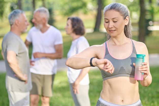 Une femme sportive avec une bouteille d'eau dans les mains