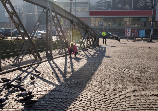 femme sportive courant sur le trottoir au jogging tôt le matin avec la scène du lever du soleil de la ville en arrière-plan