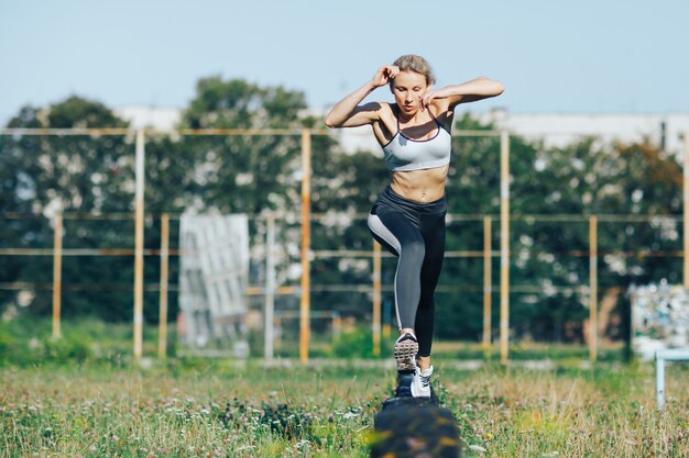 Femme sportive court et saute par-dessus les obstacles