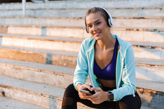 Femme sportive dans le parc en plein air, écouter de la musique.