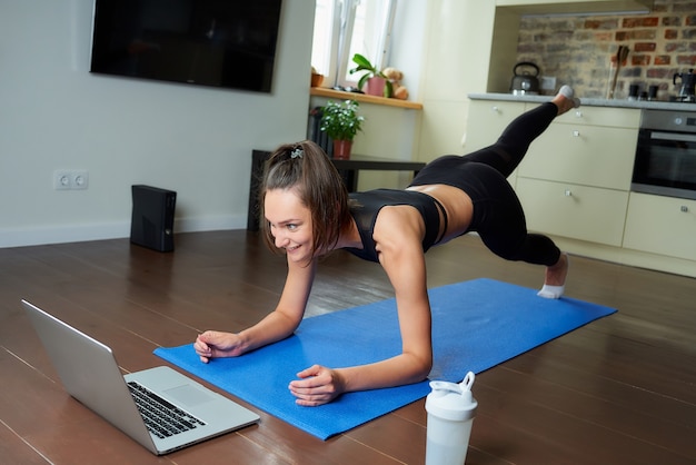 Femme sportive dans une tenue d'entraînement à la maison