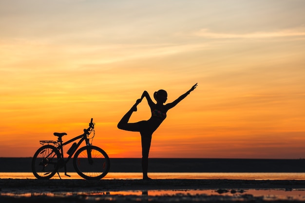 La Femme Sportive Faisant Du Yoga Au Lever Du Soleil Sur La Plage De La Mer