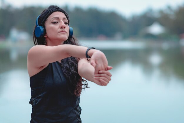 Femme sportive faisant des exercices d'étirement forts et sains étirant ses bras