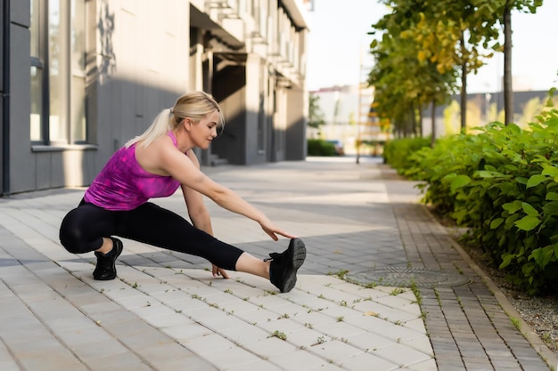 Femme sportive faisant des exercices d'étirement pendant l'entraînement croisé en plein air