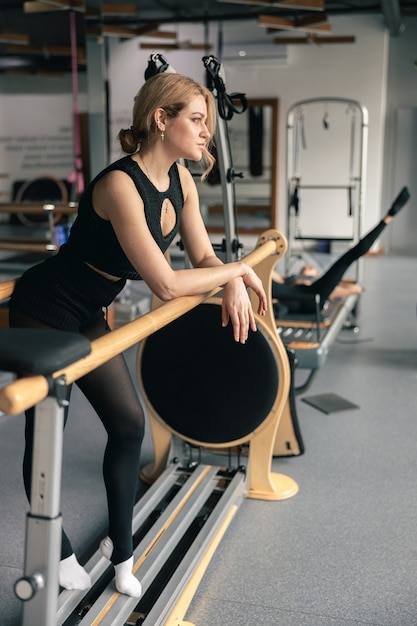 Femme sportive fait des exercices d'étirement dans un studio moderne