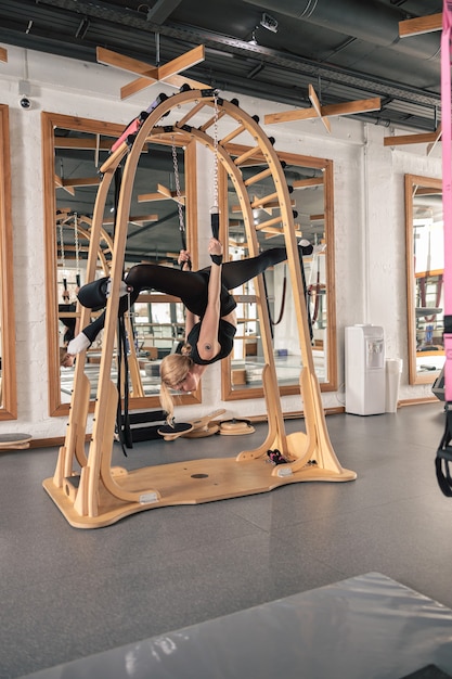 Femme sportive fait des exercices d'étirement dans un studio moderne