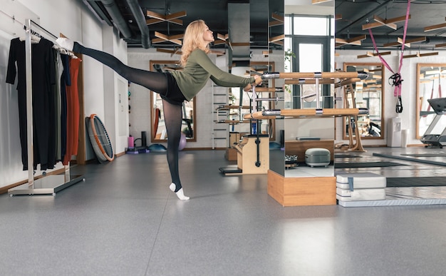 Femme sportive fait des exercices d'étirement dans un studio moderne