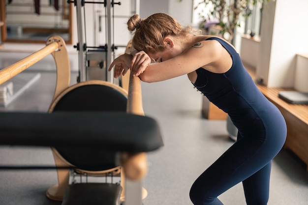 Femme sportive fait des exercices d'étirement dans un studio moderne